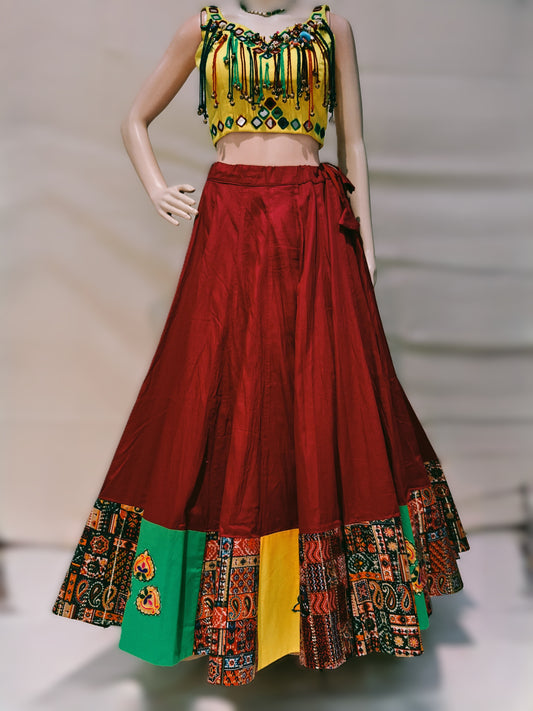 Colorful traditional outfit with a red skirt and patterned top on a neutral background