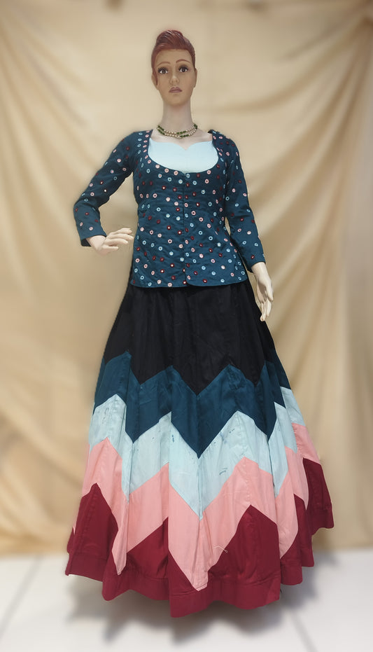 Mannequin wearing a dress with a blue top and colorful chevron pattern skirt against a beige background. Rental cloths from ClosFit  Surat.